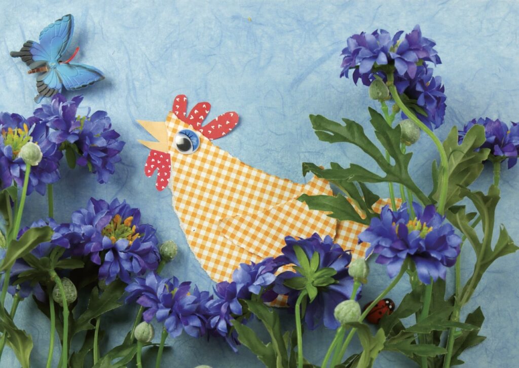 Lorelei träumt Farben: Papierhuhn zwischen Blumen
